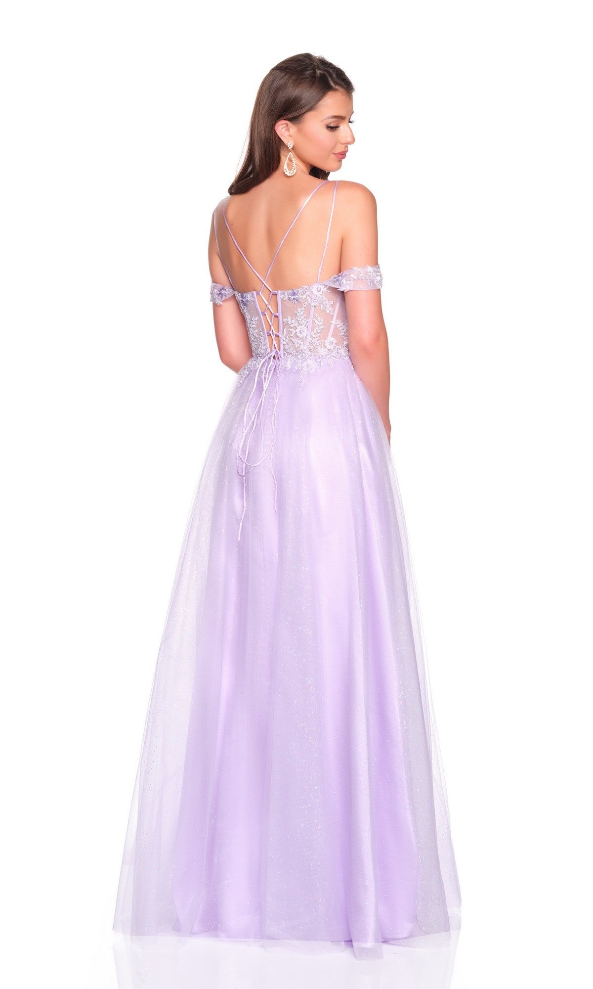 A woman stands against a white background wearing the Long Prom Dress: Dave and Johnny 12933โa purple off-the-shoulder gown with a lace-up back, sheer embroidered corset bodice, floor-length tulle skirt, and thigh-high slit.